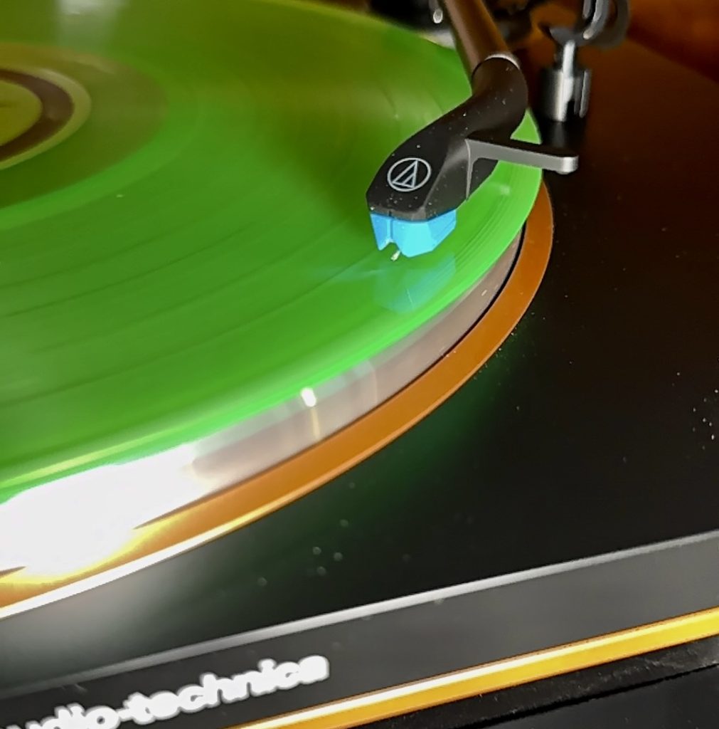 close up of green record on a black turn table